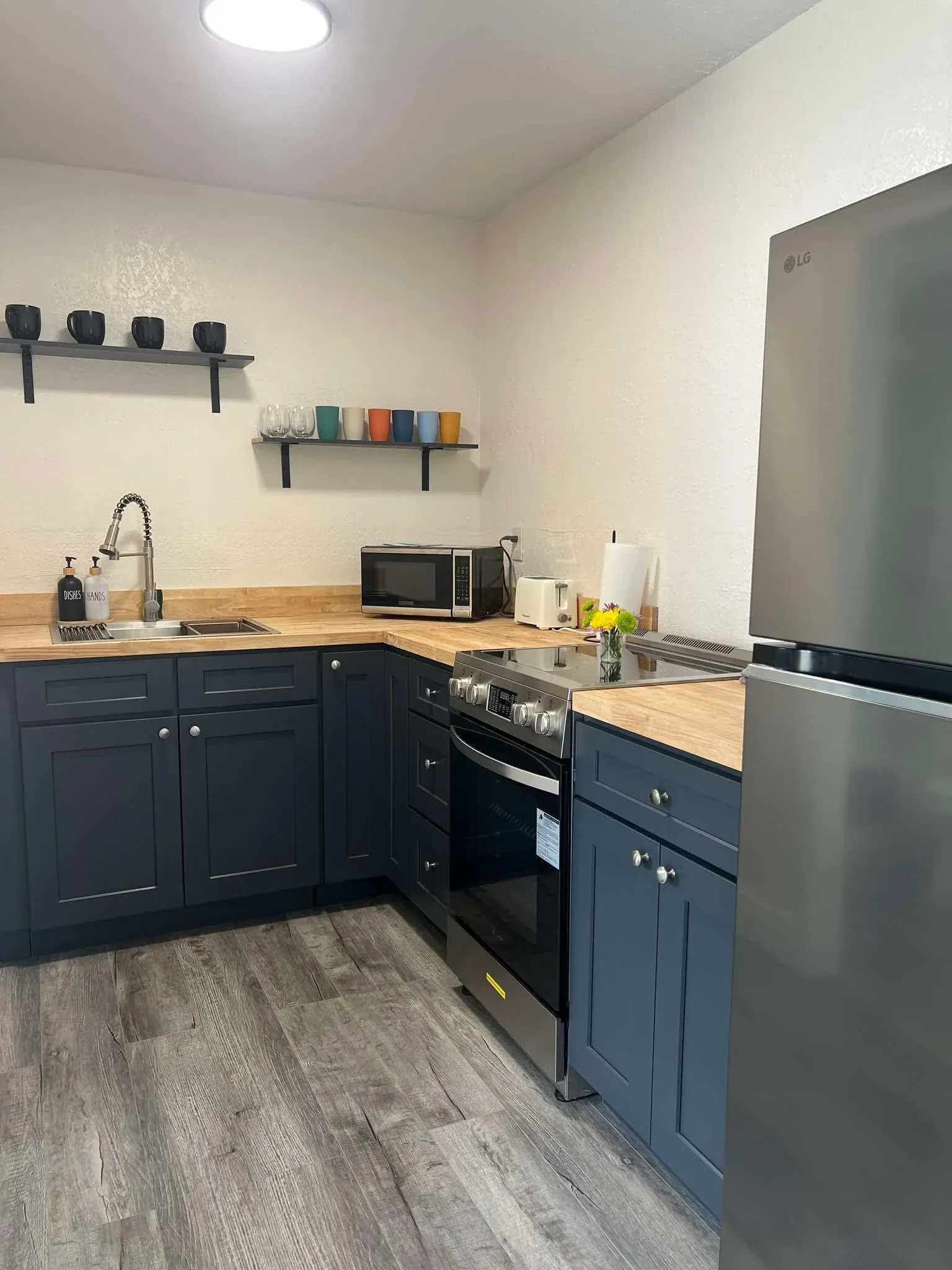 Deep cleaned kitchen with navy cabinets and stainless appliances
