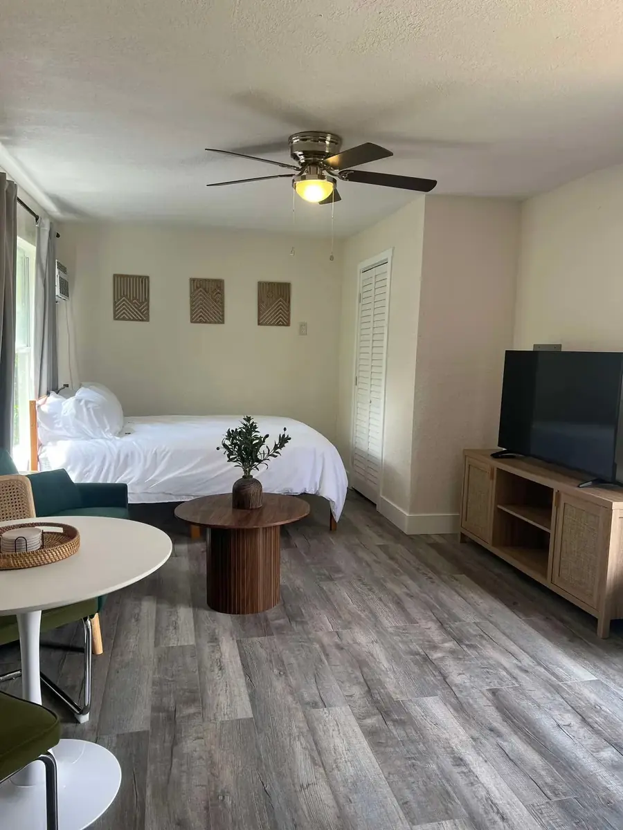 Deep cleaned studio bedroom, hardwood floors and white bedding