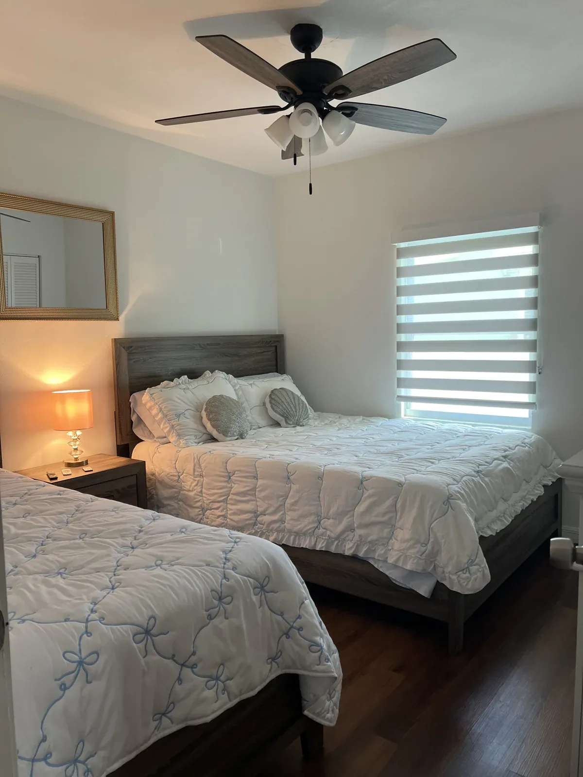 Bedroom with beds made and ceiling fan dusted