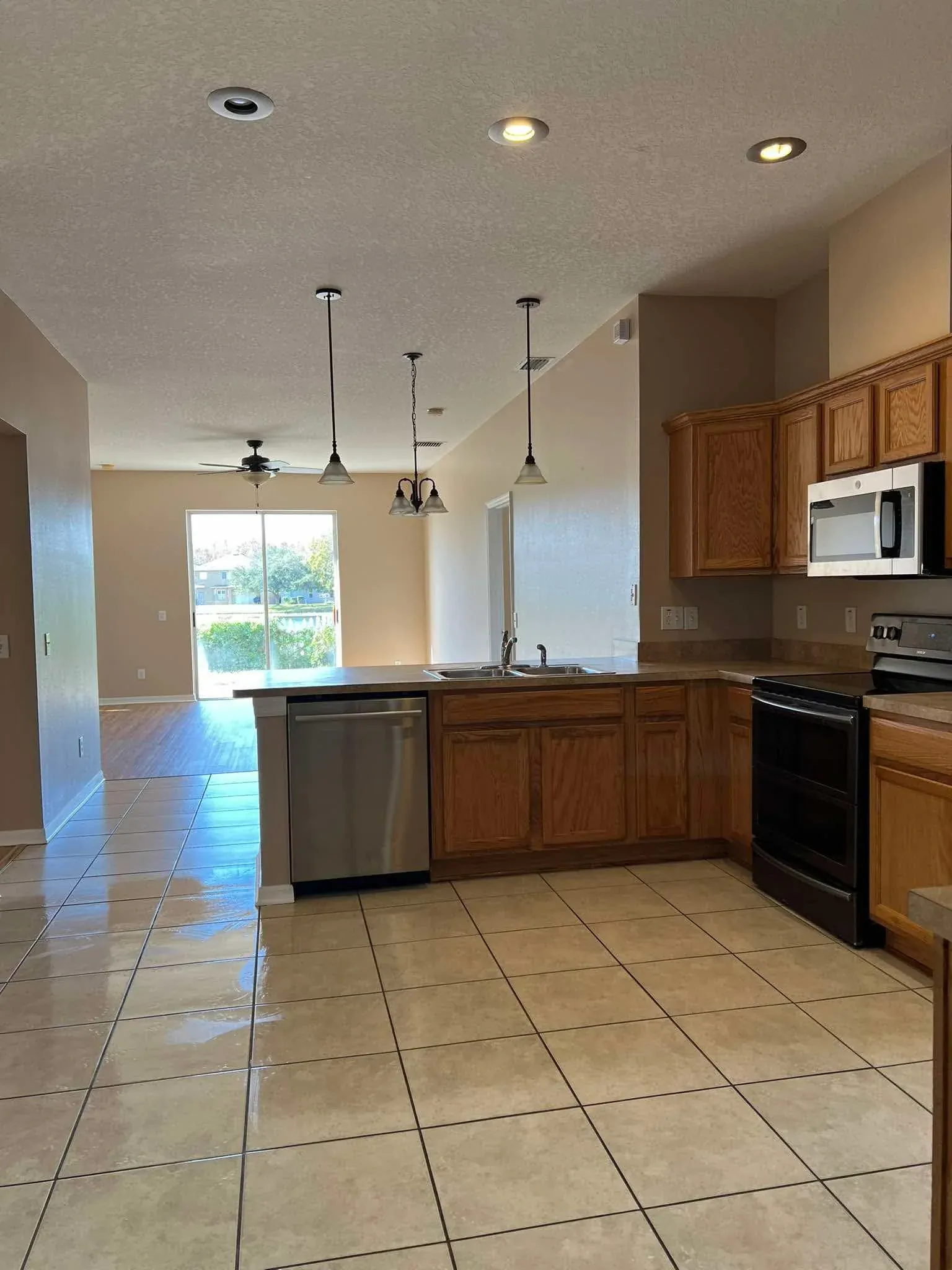 Deep cleaned kitchen open to living area, tile floors
