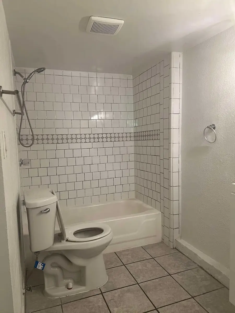 Rental bathroom with white subway tile tub and shower cleaned for move-out
