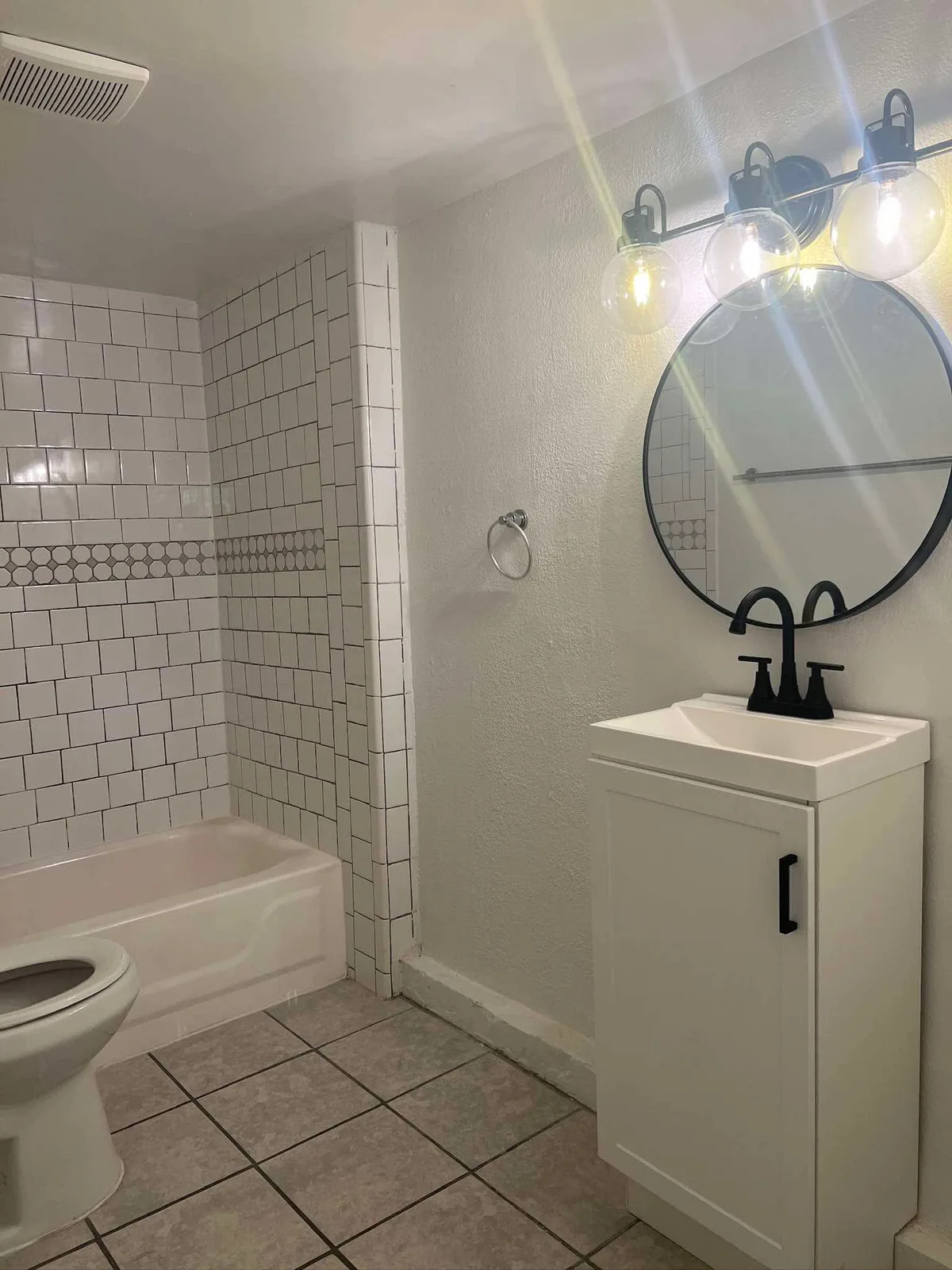 Rental bathroom deep cleaned, teal walls, white vanity and subway tile shower